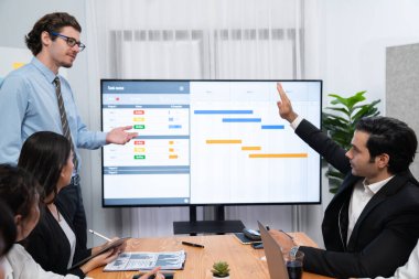 Proje yöneticisi toplantı odasında iş programları, Gantt program programı TV ekranında. Çoklu etnik çeşitlilik iş adamları ve modern iş projesi yönetimi. Habiliment