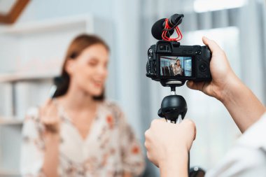 Kadın Etkilenen Vlog video görüntülerini sosyal medya ya da blog 'da en üst düzeyde yayınlıyor. Kozmetik stüdyosu ışıklandırmalı mutlu genç kız çevrimiçi pazarlama oturumu yayını için..
