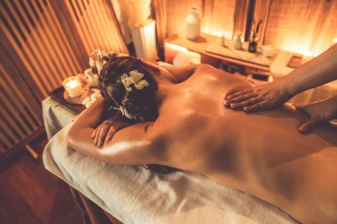 Yakından kadın müşteri strese karşı spa masajını rahatlatıyor ve lüks otel ya da otelde sıcak mum ışığında güzellik teniyle eğleniyor. Sessiz.