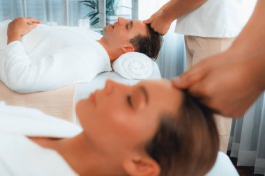 Kafkasyalı çift stres önleyici kafa masajının keyfini çıkarıyor ve lüks otellerde ya da otel spa salonlarında gündüz kaplıcalarında yüz güzelliği eğlencelerini şımartıyor. Sessiz.