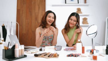 Etkilenen iki ortak canlı yayın yapan video görüntülerini sosyal medya ya da blog üzerinden gözden geçirir. Canlı kozmetik stüdyosu ışıklandırması olan mutlu genç bir kız pazarlama için internet üzerinden yayın yapıyor..