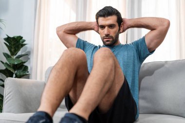 Atletik vücut ve aktif sporcu, sağlıklı vücut çalışma yaşam tarzı konsepti olarak neşeli ev egzersizlerinde kas kazanma egzersizi yapmak için mobilyaları kullanıyor..