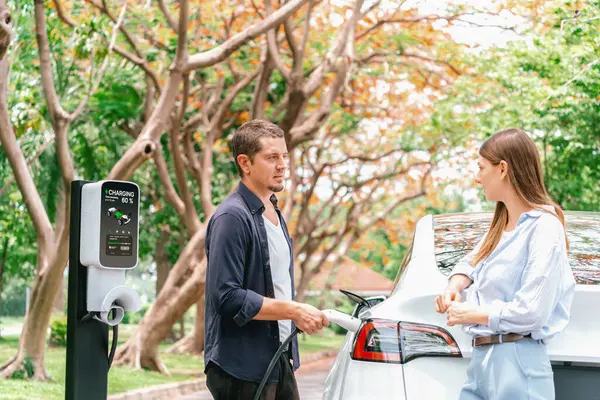 Mooi Jong Echtpaar Opladen Batterij Voor Elektrische Auto Tijdens Herfstreis — Stockfoto