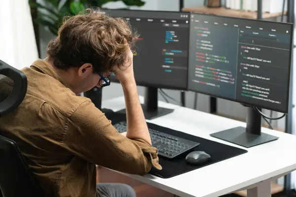 IT developer working online software development on pc monitors at modern home office on coding application screens, creating updated latest program firmware information version concept. Gusher.
