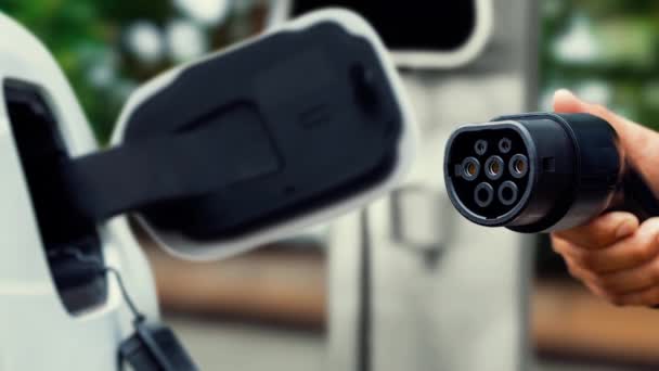 聚焦电动汽车充电器指向相机前显示未来智能数字电动汽车电池状态全息图 电动汽车充电器使用替代能源促进可持续电力 仔细阅读 — 图库视频影像