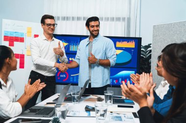 Analist ekip lideri, iş zekası ya da BI gösterge paneli ile FIntech yazılım gücünü kullanarak başarılı veri analizi toplantısından sonra iş arkadaşıyla tokalaştı. Tedbirli