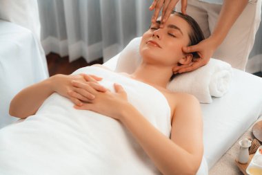 Kafkasyalı kadın stres önleyici kafa masajından ve lüks tatil beldesi ya da otel spa salonundaki modern ışık ortamında yüz güzelliği eğlencelerini şımartmaktan hoşlanıyor. Sessiz.