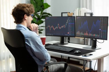 Mevcut pazar grafiğinde dinamik finans yatırımı arayan borsa simsarının genç yatırımcısı, modern ofiste gerçek zamanlı yoğunlaşıyor, istatistiksel karı analiz ediyor. Toplayıcı.