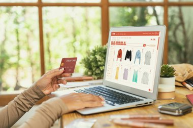 İnternet pazarından alışveriş yapan kadın modern yaşam tarzı için satış malzemeleri arıyor ve önemli siber güvenlik yazılımları tarafından korunan cüzdandan çevrimiçi ödeme için kredi kartı kullanıyor