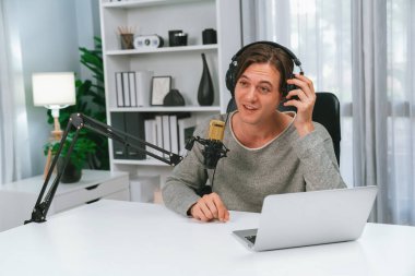 Sunucu kanalı, gülümseyen akıllı yayıncı kaydı, senaryosu ve akıllı telefonuyla sosyal medyada sohbet programı, kulaklık takarak modern ev stüdyosundaki video flamalarını kaydediyor. Bireysel.