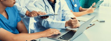 Hastane masasında birlikte çalışan ve tıbbi tedavi planlayan profesyonel tıbbi ekip. Takım çalışması başarılı hastalıklara ve hastalıklara yol açar. Panorama Katı