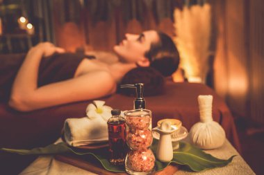 Aromaterapi masajı ambiyansı ya da spa salonu kompozisyon düzeneği bulanık kadınlara odaklı dekor mumları ve spa aksesuarları ile tatil köyü veya otel arka planında keyifli aroma spa masajı yapan. Sessiz.