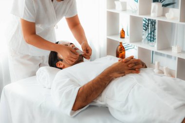 Kaplıca salonunun sakin, modern gündüz atmosferi. Kadın müşteri yüz maskesi takarak kendini yenilemeye çalışıyor. Yüz bakımı ve güzellik kozmetolojisi prosedürü. Sessiz.