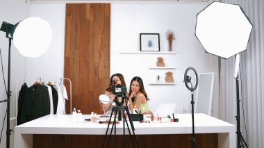 Etkilenen iki ortak canlı yayın yapan video görüntülerini sosyal medya ya da blog üzerinden gözden geçirir. Canlı kozmetik stüdyosu ışıklandırması olan mutlu genç bir kız pazarlama için internet üzerinden yayın yapıyor..