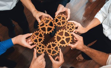 İş ekibinin dairesel olarak çarka katılması, başarılı bir iş ortaklığı grubunu ve verimli bir verimlilikle toplum işyerinde güçlü bir birlik takım çalışmasını sembolize eder. Tedbirli