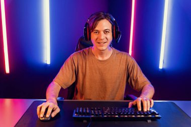 Kazanmak için çevrimiçi oyun oynayan akıllı flama makinesinin sunucu kanalı, neon ışıklı odada seçilen takım yarışması için izleyicilerle birlikte canlı yayında canlı yayında kulaklık takıyor. Bireysel.