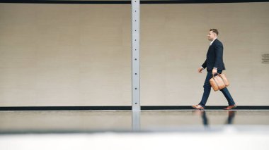 İş adamlarının bavul tutarken ve şehir merkezindeki iş yerine yürürken yan görüntüsü. Profesyonel proje yöneticisi dışarıda resmi takım elbise giyerken toplantıya gidiyor. Urbane.