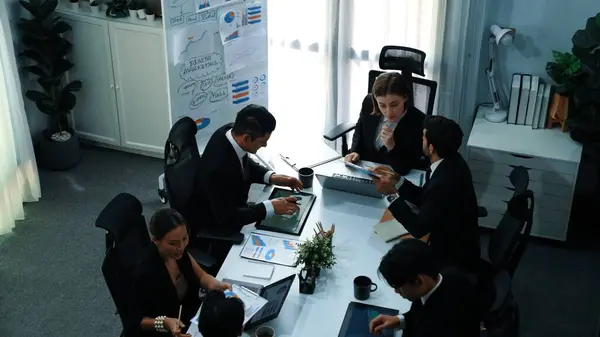 Top view of smart businesspeople working together at meeting. Manager looking at financial document while making decision to invest in stock market. Business people analyze business data. Directorate.