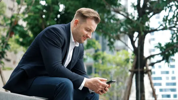 Profesionální Podnikatel Sedí Parku Zatímco Pracuje Telefonu Čtením Zprávy Marketingového — Stock fotografie