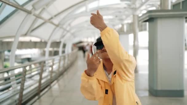 亚洲嬉皮士移动到嘻哈音乐和挥手的服装 专业的霹雳舞者一边走路 一边看着镜头 戴着耳机 穿着时髦的衣服 2024年户外运动 神气活现 — 图库视频影像