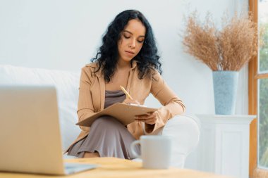 İnternette önemli bir iş için dizüstü bilgisayar kullanan Afro-Amerikalı bir kadın. Evde çalışan sekreter veya çevrimiçi içerik yazma.