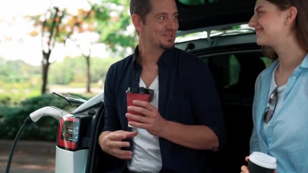 Jonge Echtpaar Drinken Koffie Opladen Batterij Voor Elektrische Auto Tijdens — Stockvideo