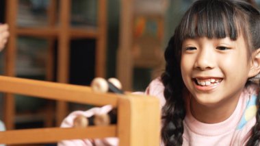 Arkadaşlarıyla oyun odasında oynaşan Asyalı tatlı bir kızın yakın çekimi. Çeşitli çocuklar hayal gücünü geliştirmek için araba modeli kullanıyorlar. Sevimli çocuklar robotik modelcilik oynamaktan hoşlanırlar. Eğitici bir oyun. Etkinlik.