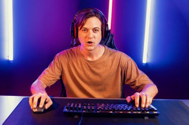 Kazanmak için çevrimiçi oyun oynayan akıllı flama makinesinin sunucu kanalı, neon ışıklı odada seçilen takım yarışması için izleyicilerle birlikte canlı yayında canlı yayında kulaklık takıyor. Bireysel.