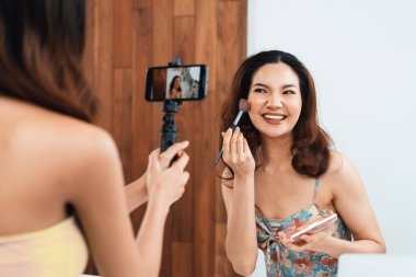 Kadın Etkilenen Vlog video görüntülerini canlı olarak çekiyor. Makyajın çoğu sosyal medya ya da blog 'u anlatıyor. Kozmetik stüdyosu ışıklandırmalı mutlu genç kız çevrimiçi pazarlama oturumu yayını için..