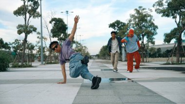 Çekici dansçı break dans yapar ya da arkadaşının önünde serbest dans eder ve ona tezahürat yapar. Profesyonel yakışıklı parkta şık elbiseler giyerken ayak hareketleri yapıyor. Açık hava sporu 2024. Yumuşak bir şekilde..