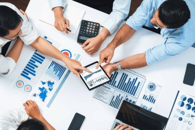 Üst düzey analist ekibi toplantı odasındaki mali verileri analiz etmek için BI Fintech 'i kullanıyor. İş anlayışı ve stratejik pazarlama planlaması için kağıt üzerinde analitik BI gösterge paneli. Tedbirli