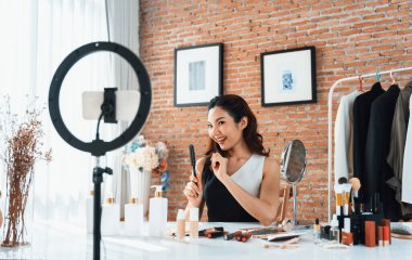 Kadın Etkilenen Vlog video görüntülerini canlı olarak çekiyor. Makyajın çoğu sosyal medya ya da blog 'u anlatıyor. Kozmetik stüdyosu ışıklandırmalı mutlu genç kız çevrimiçi pazarlama oturumu yayını için..