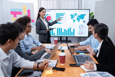 Genç Asyalı iş kadını modern toplantıda TV ekranında veri analizi paneli sunuyor. Bir grup iş adamıyla konferans odasında iş sunumu. Uyum