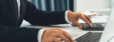 Şirket muhasebecisi, mali veri raporuna dayanarak vergi iadelerini hesaplamak ve en yüksek seviyeye çıkarmak ve finansal performansı artırmak için hesap makinesi kullanır. Panorama 'daki modern muhasebe. Kurnaz.