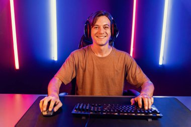 Kazanmak için çevrimiçi oyun oynayan akıllı flama makinesinin sunucu kanalı, neon ışıklı odada seçilen takım yarışması için izleyicilerle birlikte canlı yayında canlı yayında kulaklık takıyor. Bireysel.