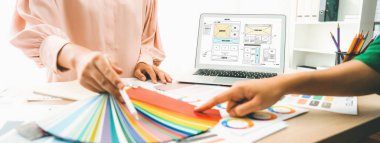 İç mimarın kırpılmış resmi renk örneklerinden renk seçerken, dizüstü bilgisayar cep telefonu uygulaması ve web sitesi için wirefram tasarımları göstermektedir. Yaratıcı tasarım ve iş konsepti. Değiştirilmiş.