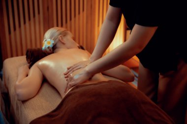 Beyaz kadın müşteri stres önleyici spa masajının keyfini çıkarıyor ve lüks otel ya da otelde sıcak mum ışığında güzellik teniyle eğleniyor. Sessiz.