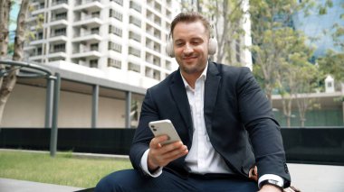 İş adamları, Green City 'deki pazarlama ekibinden gelen satış raporlarını kontrol etmek için telefona bakarken dinlendirici müzik dinlemek için kulaklık takıyor. Happy proje yöneticisi telefon beklerken şarkıya geçiyor. Urbane.