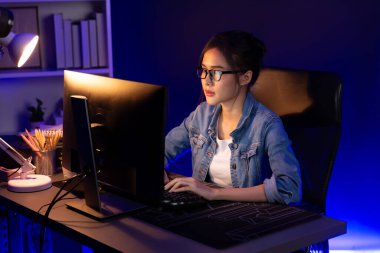 Genç, Asyalı yaratıcı bir kadının satış hedefi raporundan elde ettiği karı analiz etmesi, e-posta ile iş piyasası raporlarını karşılaştırması, gece neon ışığı altında not defterine not yazması. Taktik.