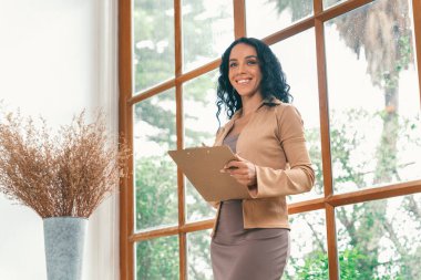 Klinikteki psikolog kadın. Profesyonel portresi. Dostane gülümsemesiyle hastayı psikoloğa davet ediyor. Deneyimli ve kendinden emin psikolog çok önemli bir uzmandır.