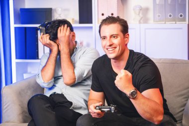 Kazanan ve kaybeden arkadaş oyuncular televizyonda video oyunu oynuyorlar. Stüdyo odasında neon mavi ışıklı joystickler kullanıyorlar. Memlekette rahat bir yaşam ve neşeli bir dövüş kazananı. Satılabilir.