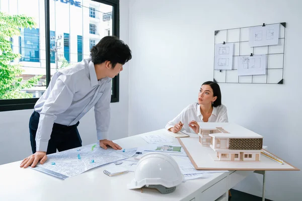 Professional architect team work together and discuss about house design with blueprint, map and architectural equipment at office. Creative business design and teamwork concept. Immaculate.