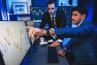 Borsa simsarları panorama manzaralı yüksek kar tablosu yatırımlarına bakıyor, geceleri monitörde analiz ediyorlar. İş yerinde finansal teknoloji gelişimini neon ışığında tartışma kavramı. Satılabilir.