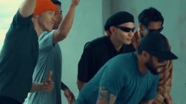 Hip-hop müzik eşliğinde dans eden bir grup genç çok kültürlü hippi. Profesyonel break dansçı takımı şık kıyafetler giyerken sokak dansı yapar ya da pratik yapar. Açık hava sporu 2024 hiphop..