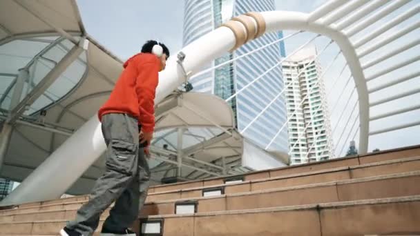 Aziatische Hipster Draagt Koptelefoon Show Voetstap Tijdens Het Springen Stad — Stockvideo