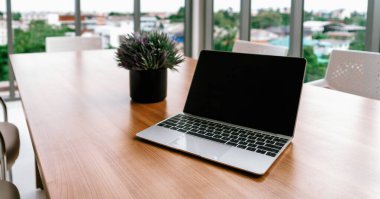 Ofis çalışma alanındaki masada açık kapaklı dizüstü bilgisayar. uds