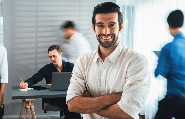 自信和快乐的微笑的商人肖像与模糊的运动背景 他的同事和在办公室工作的商业团队 办公室工作人员的团队精神和积极的工作观念 谨慎的人 — 图库照片