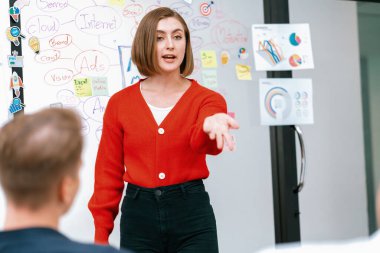 Profesyonel çekici kadın lider, modern iş toplantı odasında beyin fırtınası zihin haritalama istatistikleri ve renkli yapışkan notlar kullanarak yaratıcı pazarlama planını sunuyor. Tertemiz..