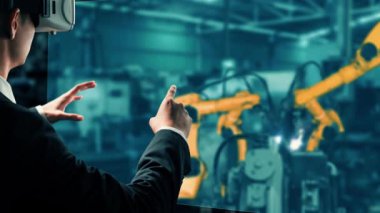 XAI Mühendisi, fabrikadaki robot kolu kontrol etmek için siber robot yazılım kullanıyor. IOT yazılımı kullanarak internet ağına bağlı uzmanlar tarafından kontrol edilen otomasyon üretim süreci.