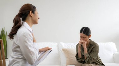 Psikologla ruh sağlığı terapisi gören üzgün travma sonrası stres bozukluğu olan bir kadın. Yaşam sonrası depresyon veya keder. Hayal kırıklığına uğramış genç bir kadın klinikteki duygular hakkında Vivancy psikoloğuyla konuşuyor.